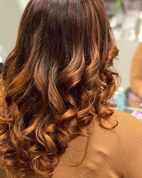 Gestufter Haarschnitt mit kupferfarbenen Locken im House of Beauty Winterthur