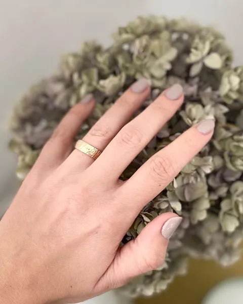 Gepflegte Hand auf einer Hortensienblüte, ruhige Wellness-Stimmung